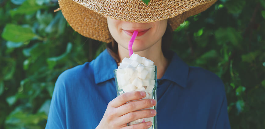 Women in hat drinking a beverage with hidden sugar