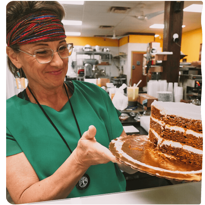 Employee holding a cake.  Pyure Commercial Sweeteners are great for bakeries that offer no sugar or keto options. 