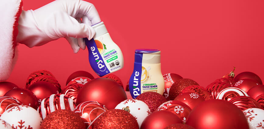 Graphic for Sugar-free Gifts blog post with santa arm and Christmas ornaments and Pyure liquid stevia