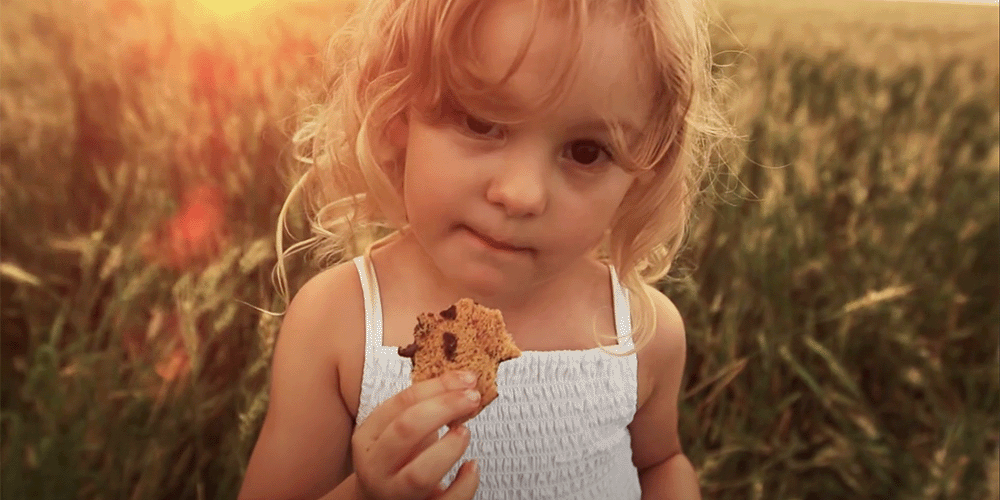 Little girl eating a sugar free cookie. Enjoy Pyure Organic keto chocolate chip cookie mix. 