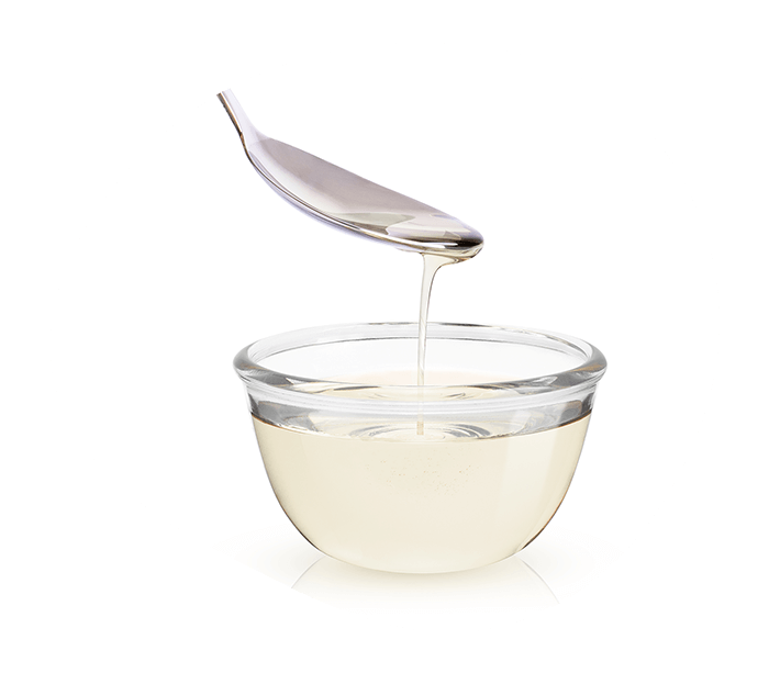 Allulose sweetener syrup in a glass jar with spoon.